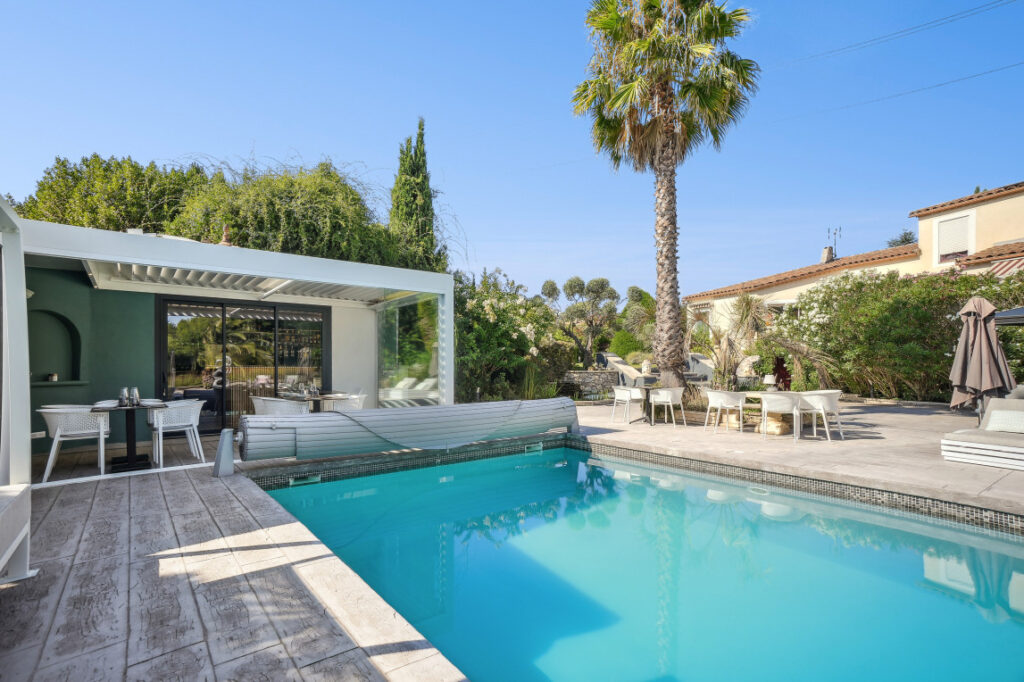Piscine extérieure avec terrasse, palmier et espace réception dans une propriété haut de gamme à Sommières