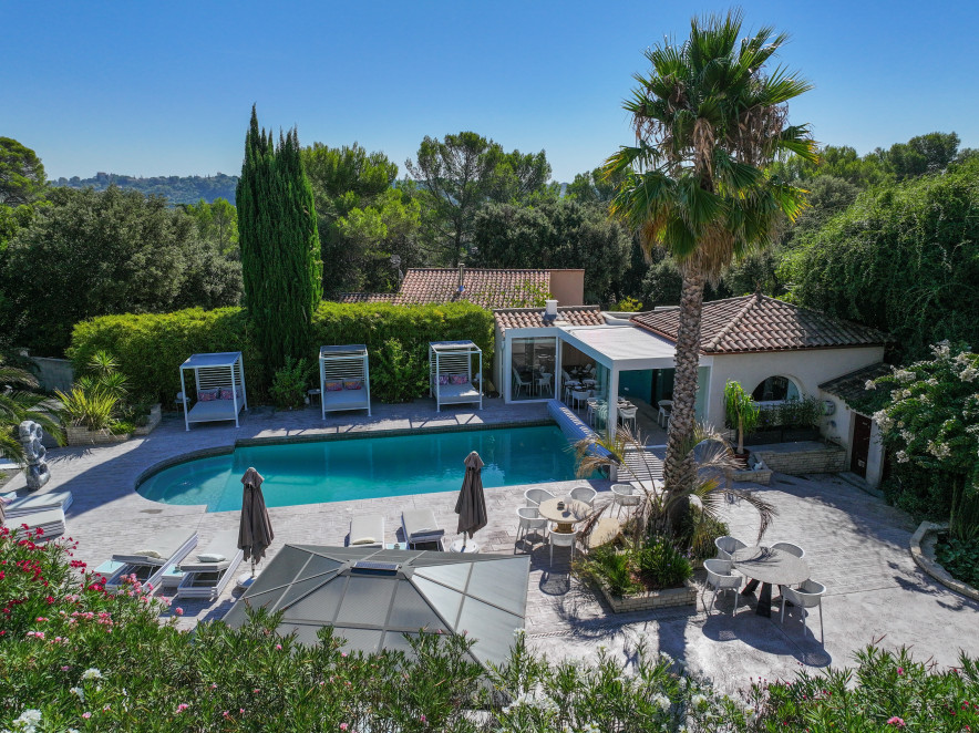 Piscine de Casa Dina à Sommières avec terrasses, palmiers et espaces détente dans un cadre verdoyant
