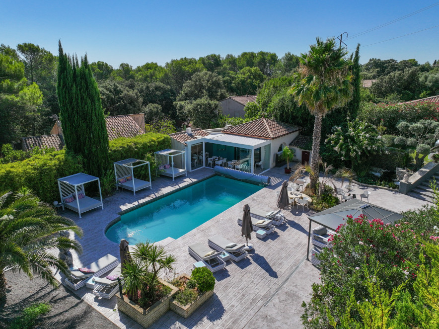 Vue panoramique de Casa Dina à Sommières avec piscine extérieure, transats et propriété arborée dans le Gard