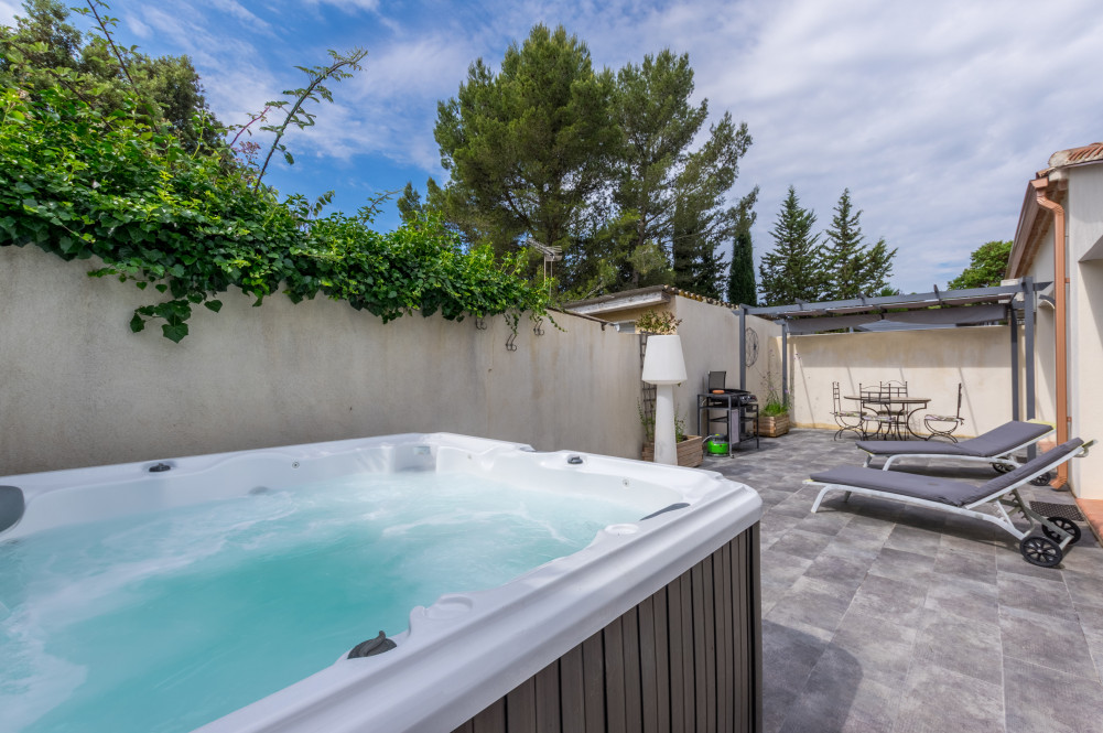 Terrasse extérieure avec jacuzzi, bains de soleil et espace repas à Casa Dina Sommières