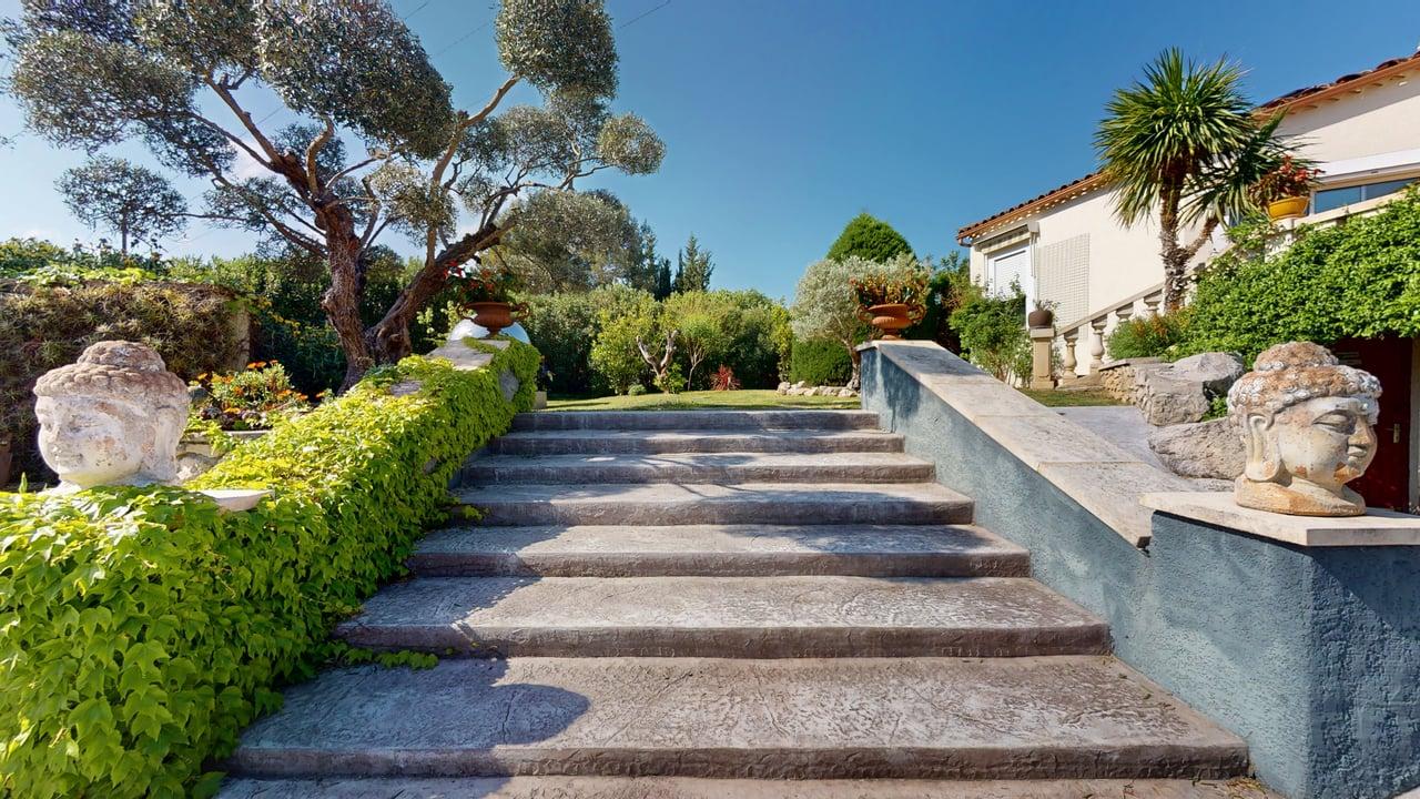 Escalier pierre têtes bouddhas jardin méditerranéen Casa Dina Sommières