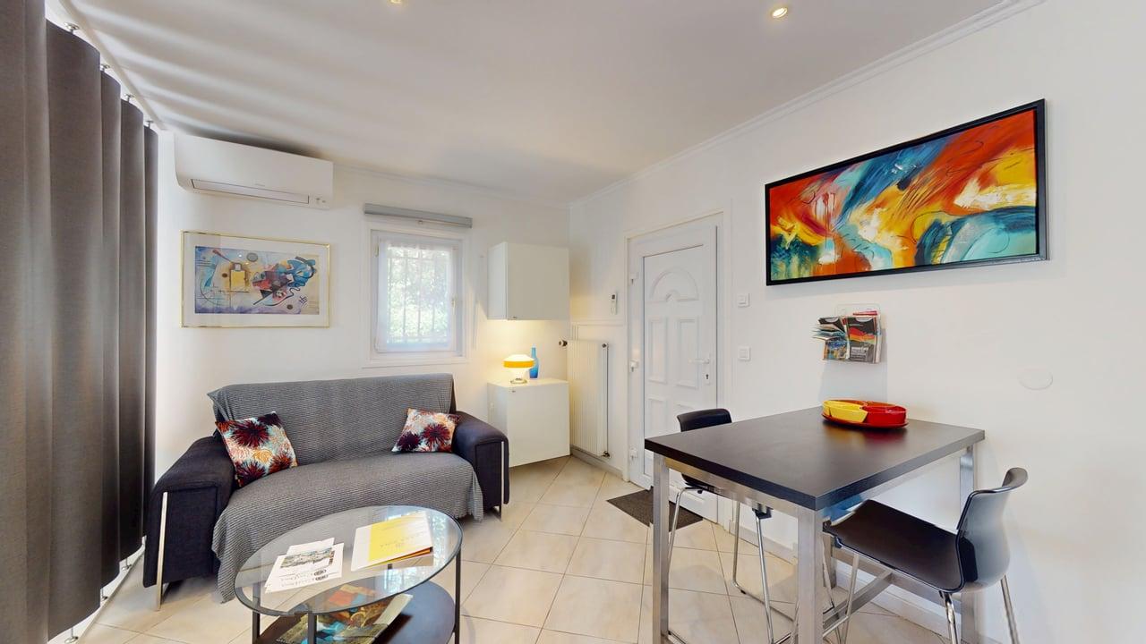 Séjour studio canapé table repas peinture abstraite lumineux Casa Dina